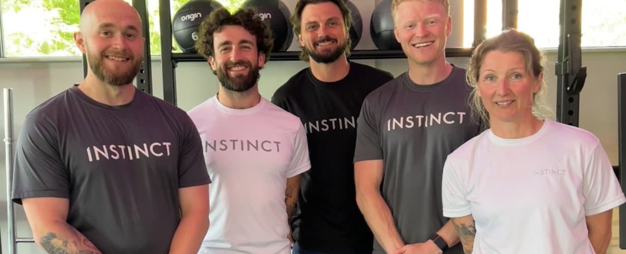 Five, friendly head coaches/person trainers with big smiles in the main gym area at Instinct Gym in Tarporley.